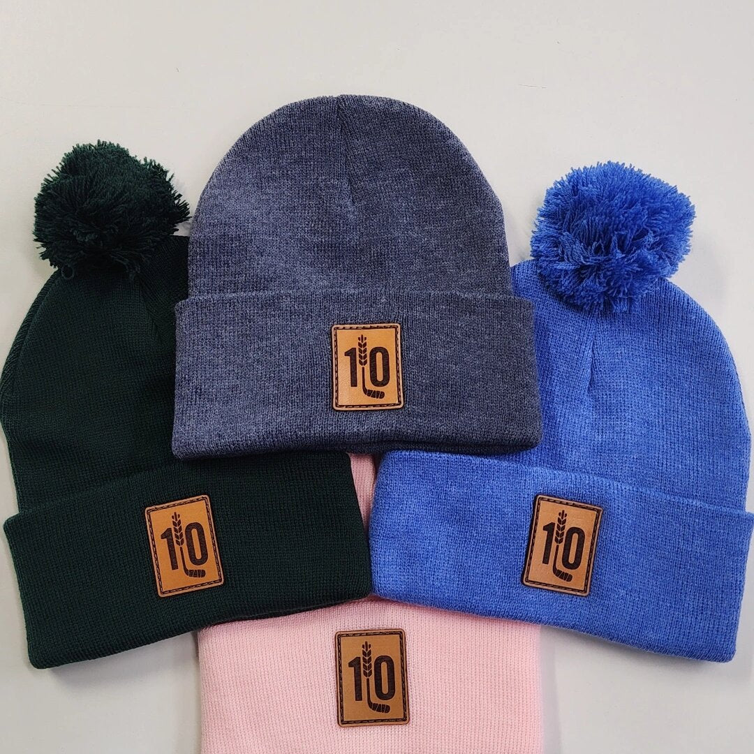 Custom pom-pom and cuffed toques with a 1LO leather patch logo in assorted colours
